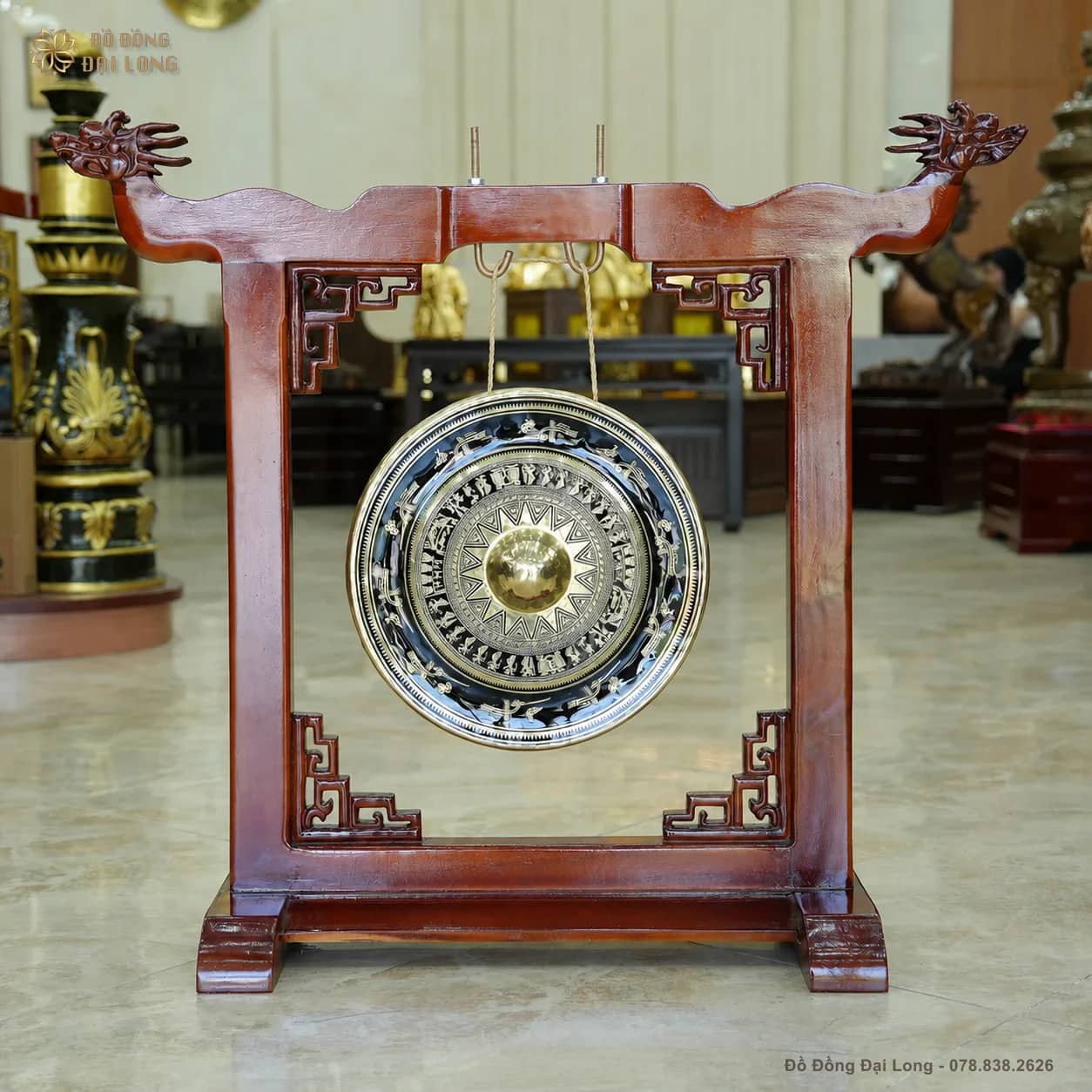 Chiêng đồng thủ công mặt tròn treo trên giá gỗ chạm đầu rồng tại Đồ Đồng Đại Long