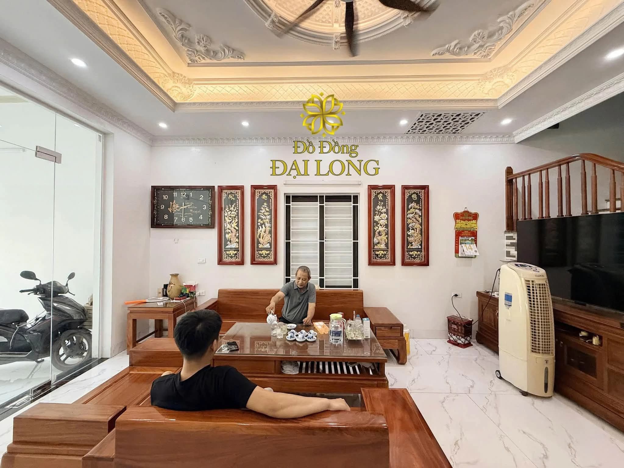 Không gian phòng khách có tranh đồng Đại Long treo trên mảng tường trung tâm