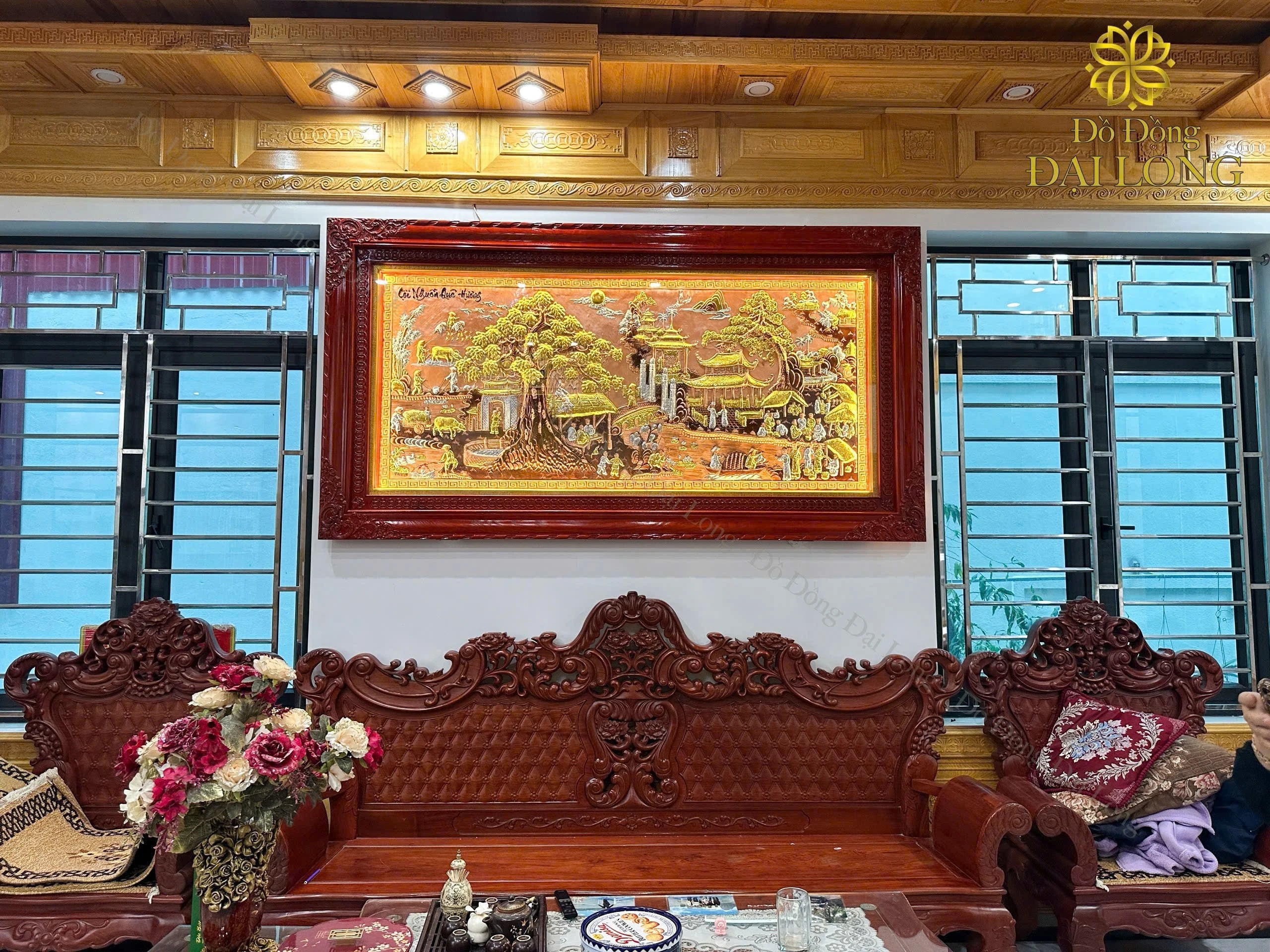 Tranh Cội Nguồn treo trong phòng khách có nội thất gỗ, ảnh thực tế do Đại Long cung cấp